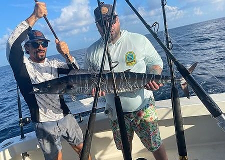 Two men hold up catch on deep fishing trip