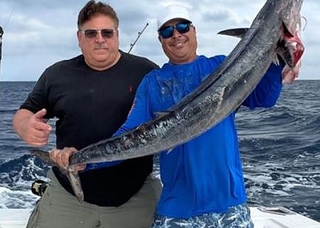  Two men hlding up a large fish