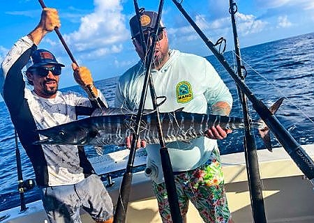 Two men hold up catch on deep fishing trip