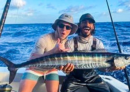 Two men hold up catch on deep fishing trip